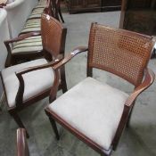 A pair of elbow chairs with cane backs