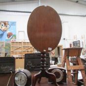 An oval oak tip tip tripod table