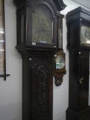 An 8 day carved oak Grandfather clock with brass face