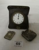 A cased travel clock, a silver vesta and a plated vesta