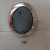 An oval silver photo frame, missing stand