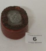 An amber pill box with pewter inset depicting lady with dove, signed 'Guyler?' on bottom