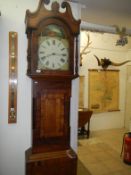 A mahogany veneer on oak 30 hour long case clock by Thos. Wilson with pendelum and weights