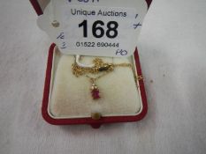 A ruby and small diamond pendant on 9ct gold chain
