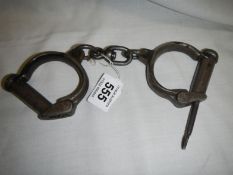 A pair of Victorian steel handcuffs with key, marked MC1 No.13