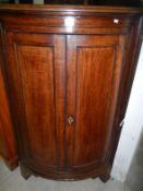 A Georgian bow fronted corner cabinet