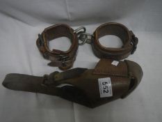 An unusual leather horse muzzle and pair of horse cuffs