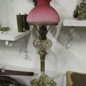 A Victorian Corinthian column peg font oil lamp with original overlaid pink glass shade