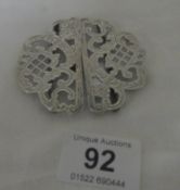 A silver nurses buckle.