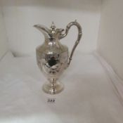 An ornate silver plated water jug