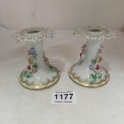 A pair of Continental hand painted porcelain candlesticks