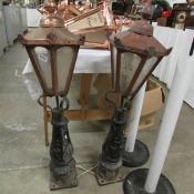 A pair of copper lanterns with gate post brackets