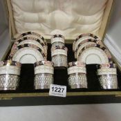 A cased 12 piece porcelain coffee set with silver holders