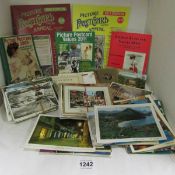 A mixed lot of old postcards and postcard reference books