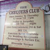 An advertising sign for 'The Chequers club'