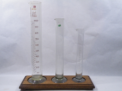 Three early 20th Century scientific measuring containers of graduated height - the glass