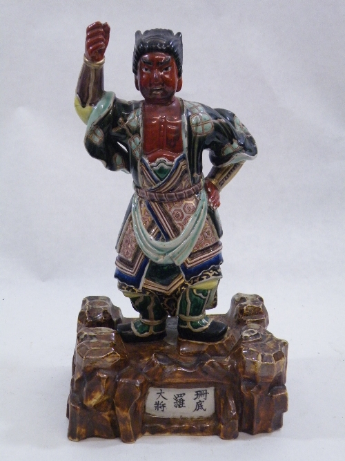 A 19th Century Oriental pottery figure of a temple guardian, the red skinned figure with