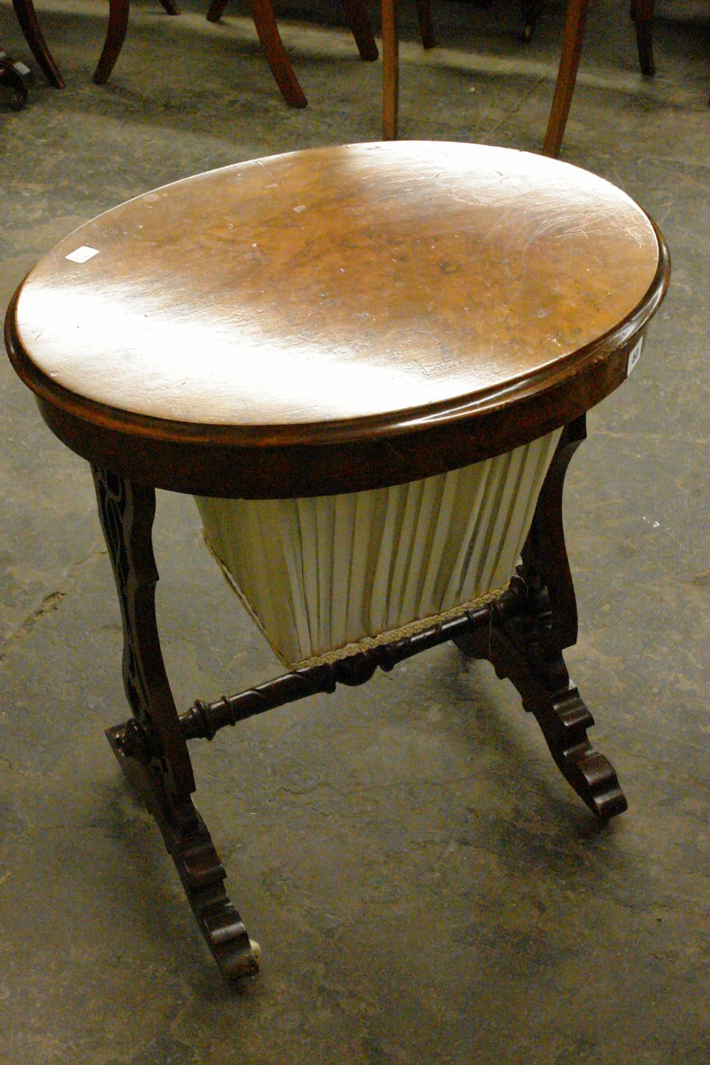 VICTORIAN WALNUT OVAL TOPPED NEEDLEWORK TABLE FITTED WITH A DRAWER OVER PLEATED SILK PULL OUT BAG ON