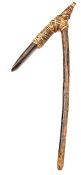 An old Polynesian or African adze, the large shaped stone blade set into a wooden handle and bound