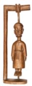 An unusual West African carved wooden figure depicting a priest hanging from a gibbet, possibly