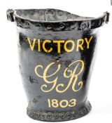 A black leather fire bucket, painted in yellow ?Victory. GR.1803?, height 10?, with copy of a photo