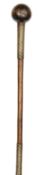 A Zulu hardwood knobkerry with ball head, the shaft decorated with two lengths of brass and steel