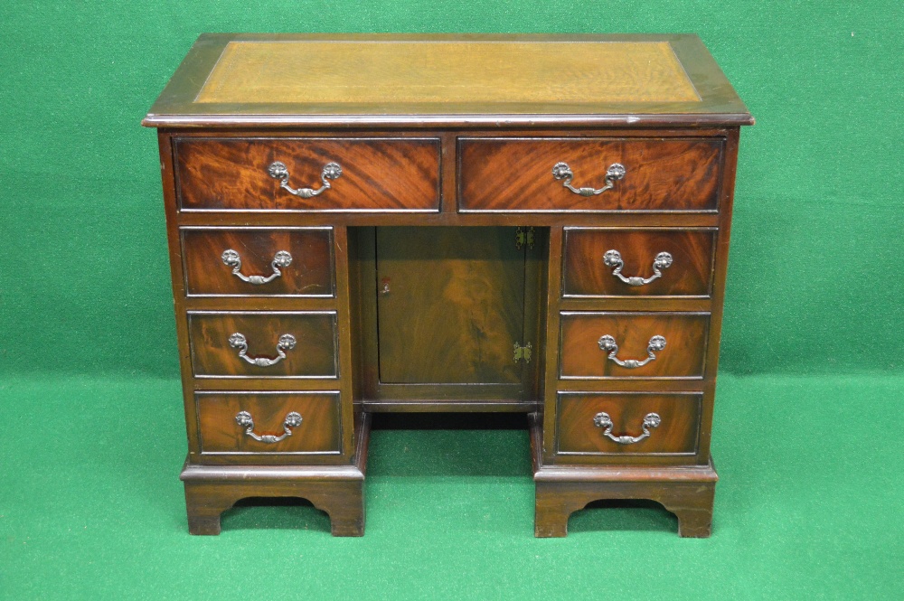 A 20th century mahogany desk having tan leather insert over two drawers and central recessed door,