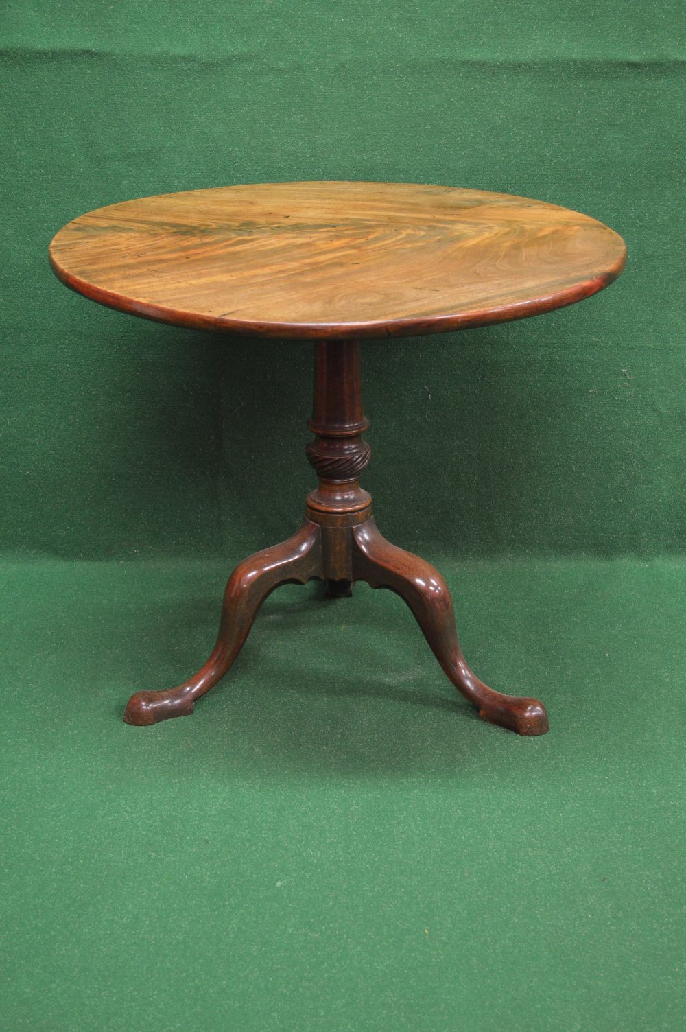 A Georgian mahogany tip top tripod occasional table having circular top supported by turned column