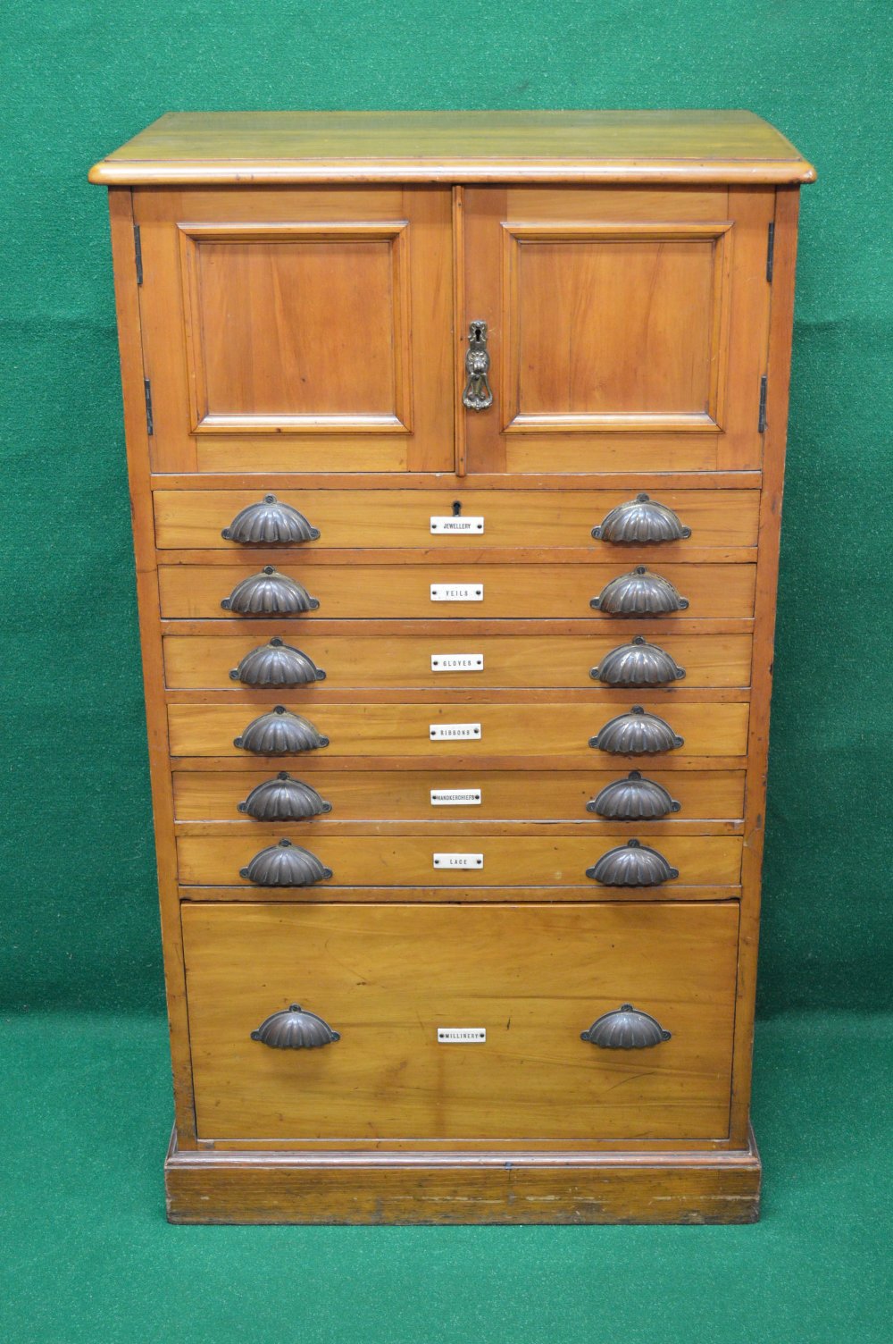 A satinwood ladies dressing cabinet having two panel doors over six narrow drawers and one deep