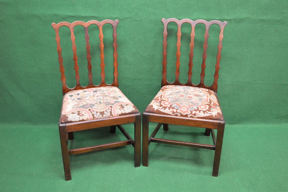 A pair of Chippendale mahogany dining chairs having shaped top rail and vertical slats leading to