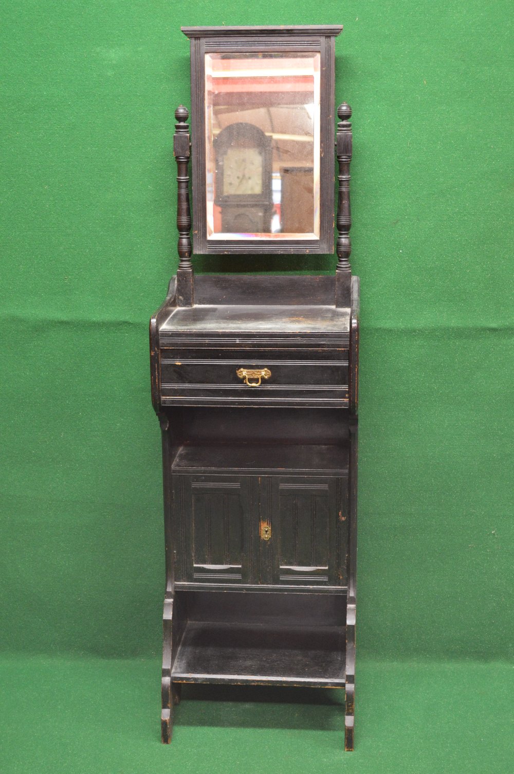 A black painted gentleman's shaving stand having swing mirror supported by turned columns leading to