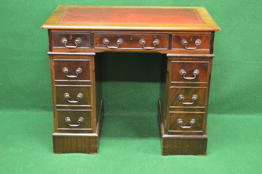 A 20th century mahogany pedestal desk having red leather insert over long central drawer flanked