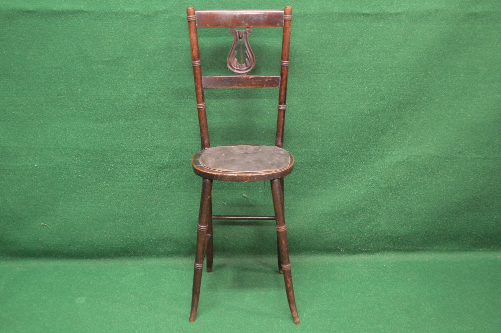 A cellists chair having lyre back splat over oval padded seat and standing on stretchered turned