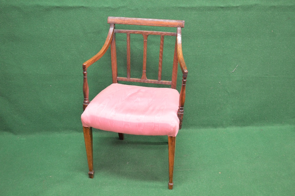 A mahogany open elbow chair having moulded top rail over three vertical reeded back splats and