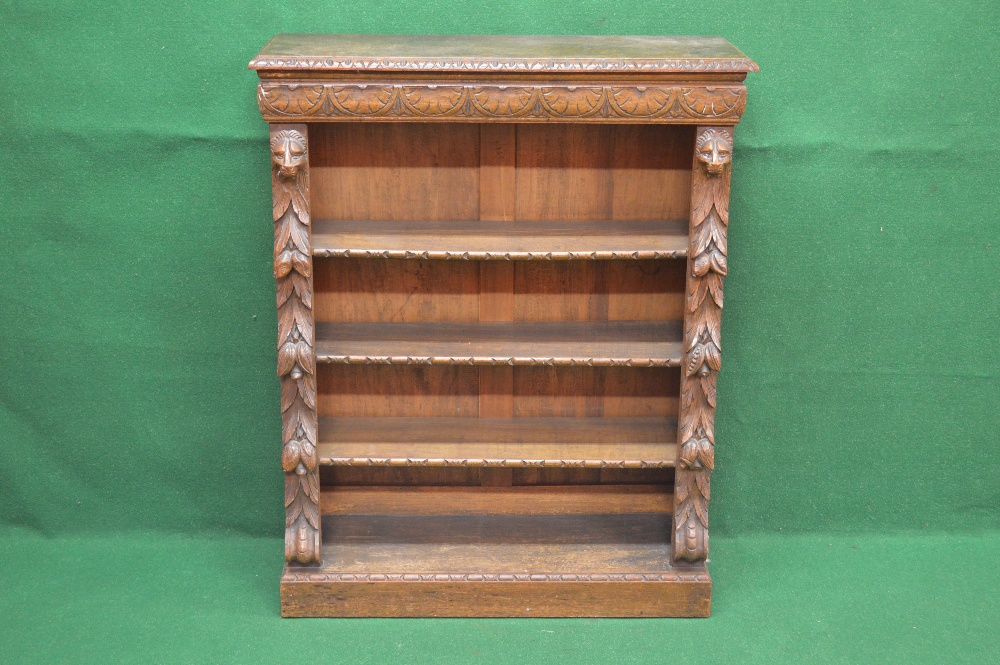 An oak carved bookcase the carved border over three adjustable shelves flanked by carved columns