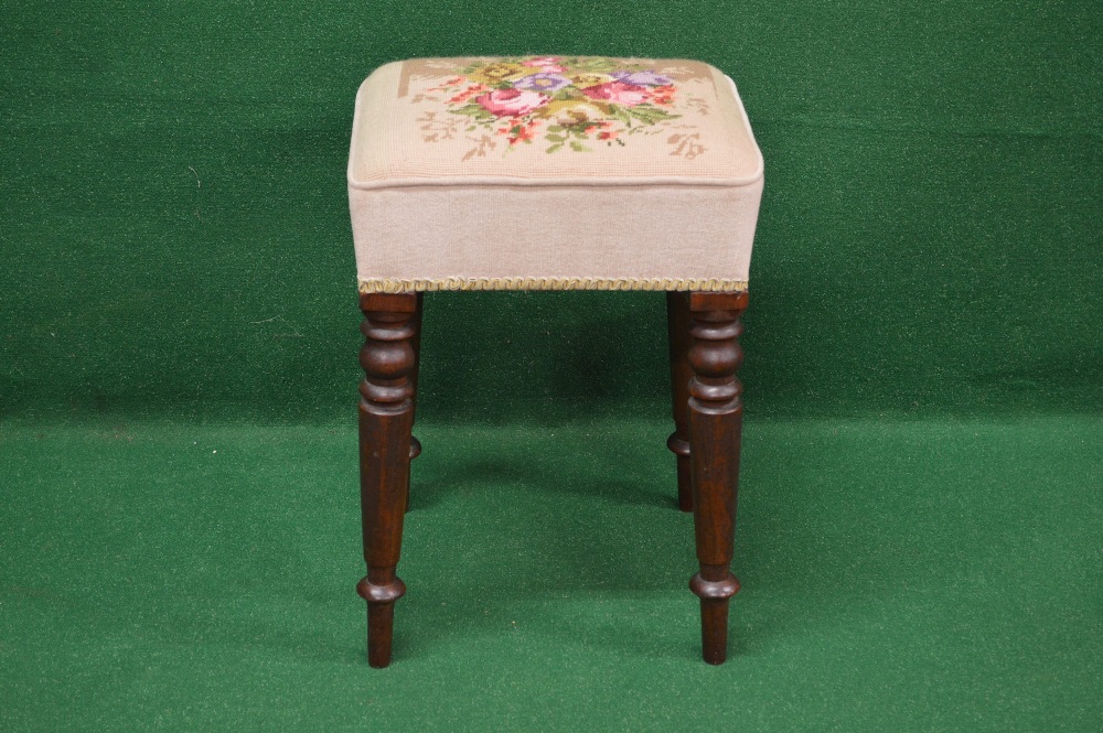 A mahogany framed dressing stool having floral needlework over stuffed seat supported by four turned