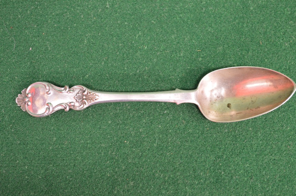 A decorative antique Russian silver serving spoon, assayed 1844