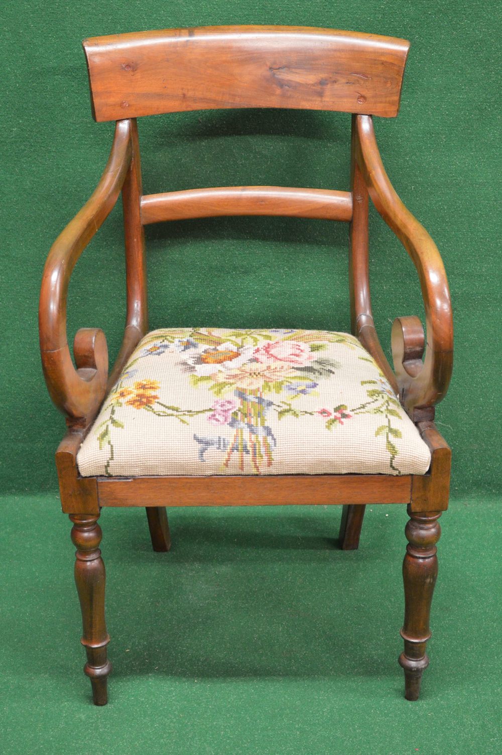 A mahogany carver chair having curved top and back rail with moulded uprights supporting scroll arms