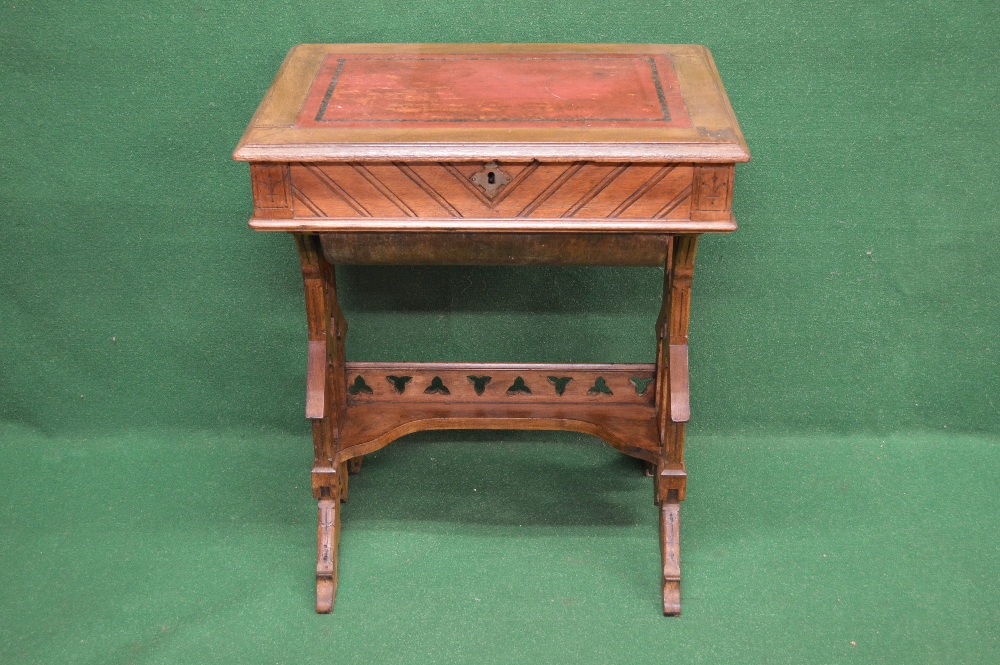 An oak Arts & Crafts work table having red leather insert with rising top opening to reveal