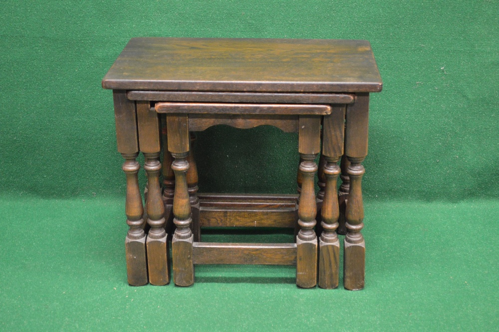 A nest of three oak occasional tables having moulded tops on turned legs ending in block feet