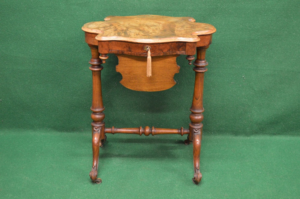 A shaped Victorian walnut work table having single drawer over sliding basket and supported on