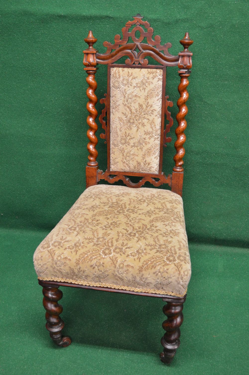 A Victorian rosewood nursing chair having pierced top rail over padded back flanked by barley
