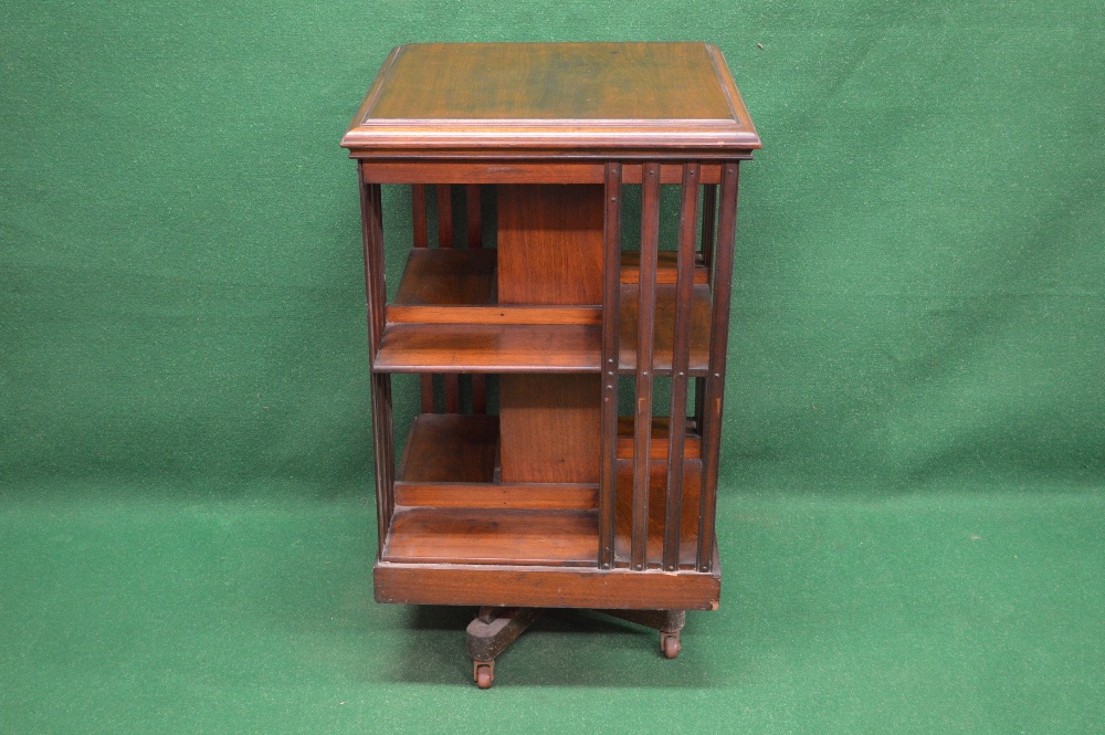 An Edwardian mahogany revolving bookcase having square moulded top and reeded slats leading to lower