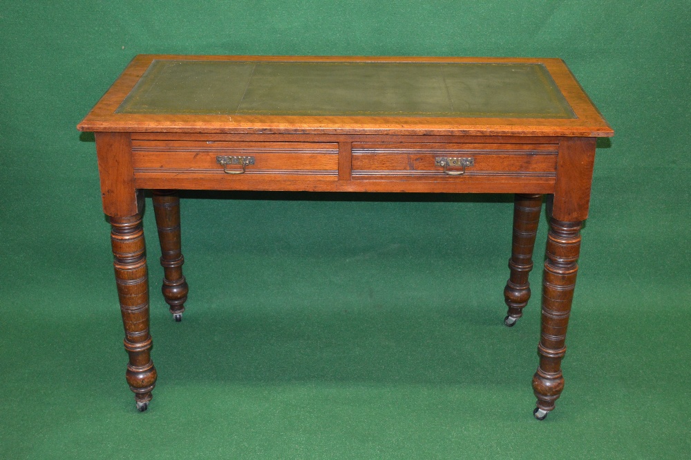 An Edwardian walnut writing table having green leather insert with gilt tool work over two short