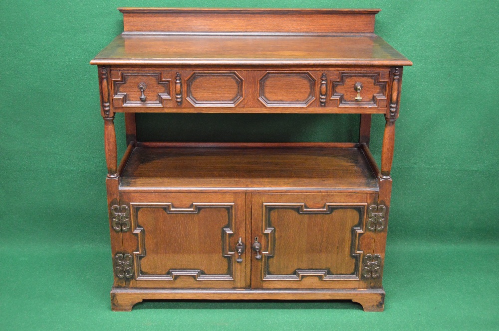 An oak Jacobean style buffet having raised back over single long drawer with brass handles,