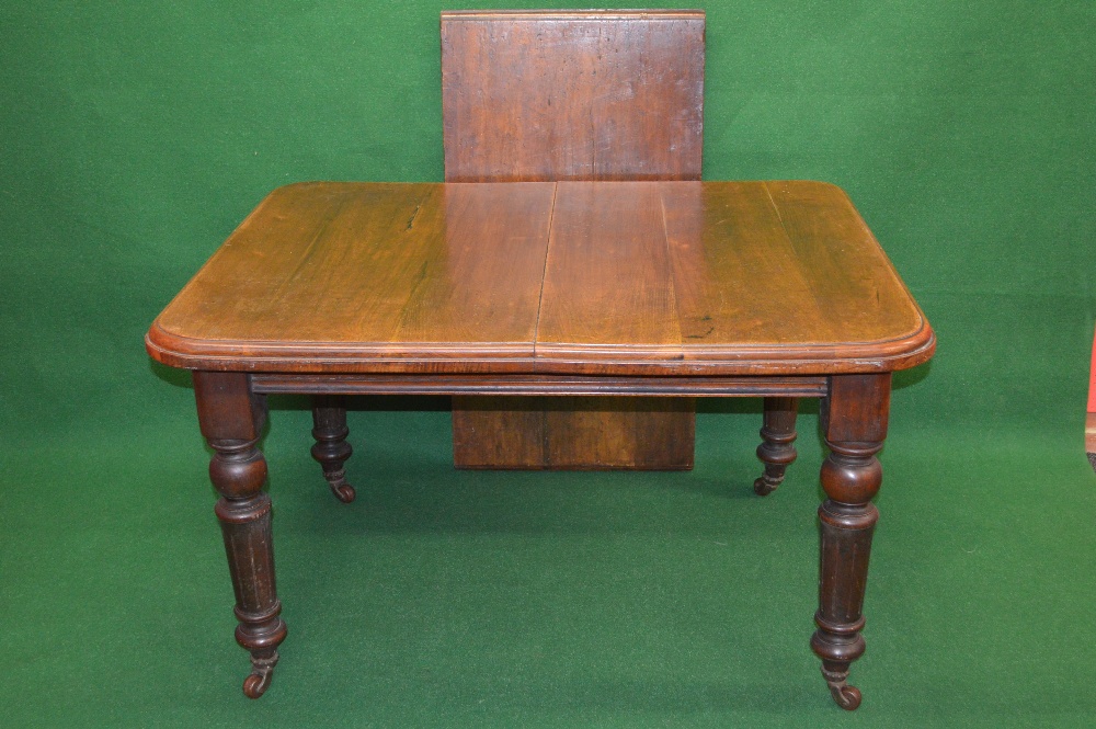 A mahogany William IV wind out dining table the top having moulded edge and standing on ball and