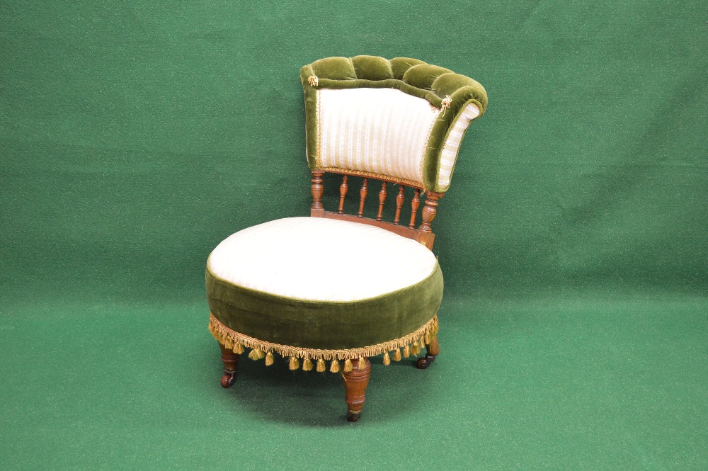 An Edwardian nursing chair having upholstered back supported by turned columns and spindles