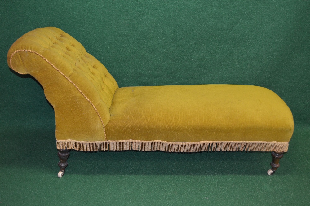 A Victorian mahogany chaise day bed in gold upholstery, having button backrest and standing on