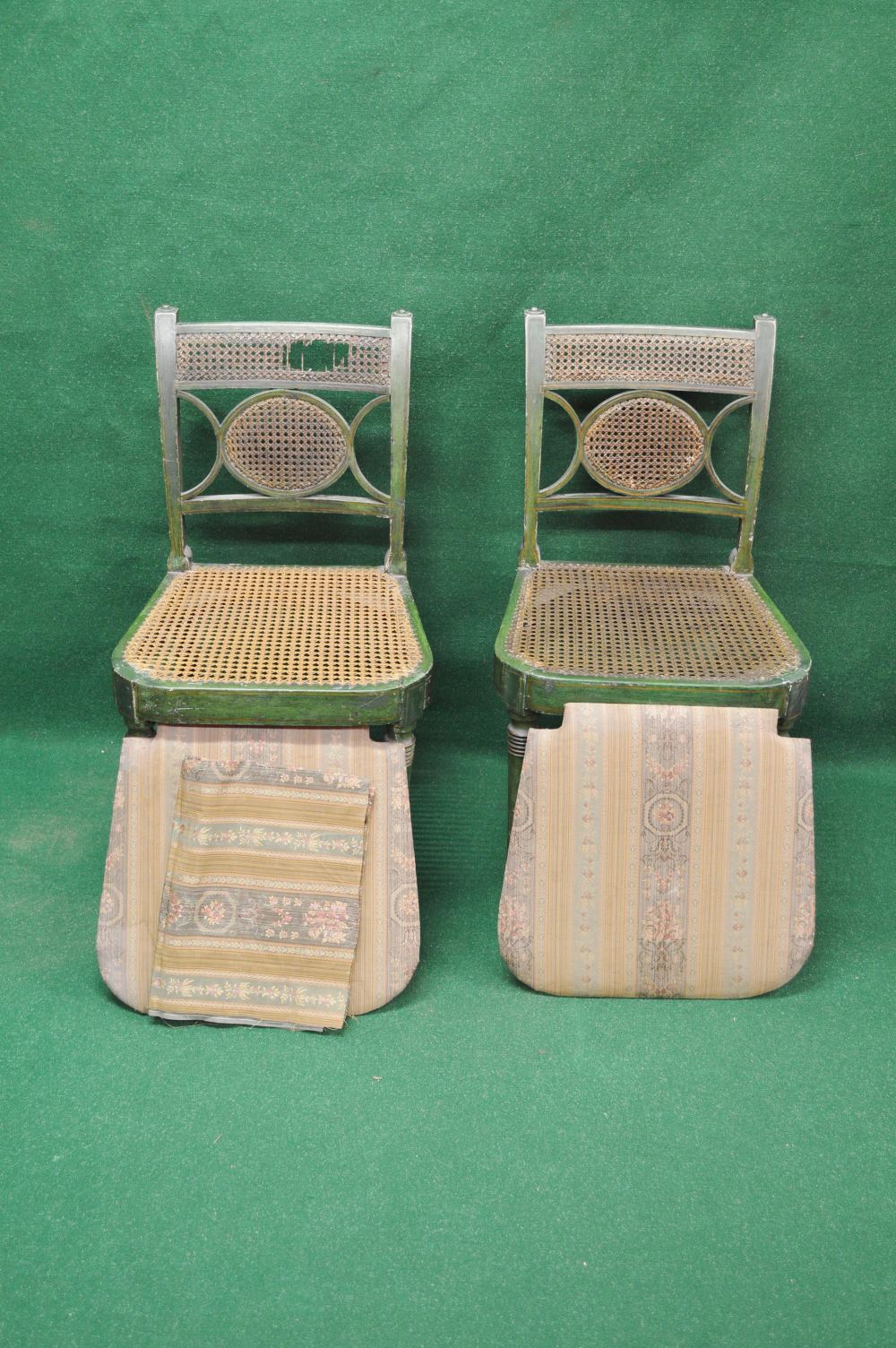 A set of green painted cane seated chairs with flat cresting rail and additional cane panels to
