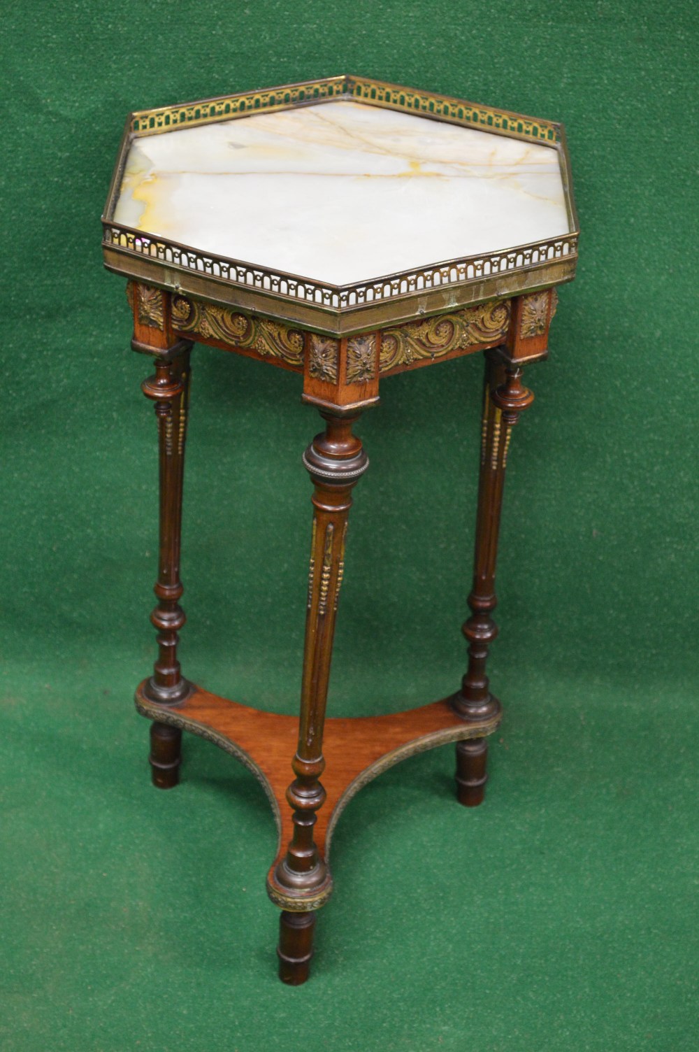 A mahogany marble topped hexagonal shaped occasional table with pierced gallery, standing on